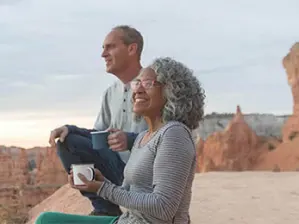 Couple drinking coffee overlooking a valley